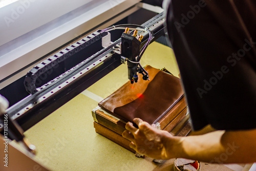 The process of making laser engraving on brown leather bags, perfect for leather industry company profile designs