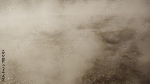 Close up shot of a steaming geyser at sunrise in El Tatio Geysers field in the Atacama Desert with volcanic terrain and dramatic light in the high Andean plateau of northern Chile