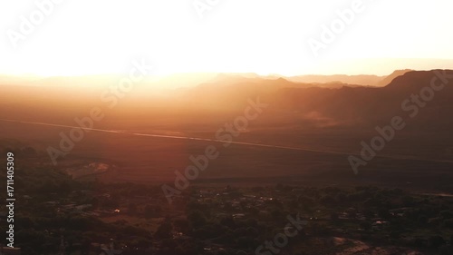 Aerial shot at sunset with the sun setting behind the rocky mountains of the Moon Valley in the Atacama Desert creating a dramatic golden light over one of the most iconic landscapes in Chile
