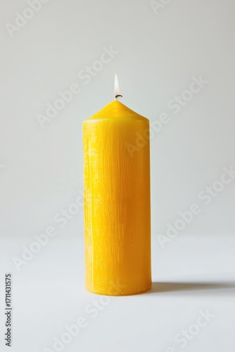 A single yellow candle with a flame, set against a neutral background.