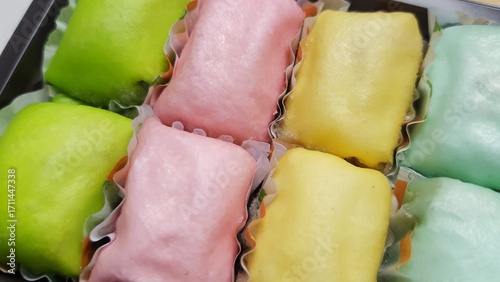 Canvastavla Assorted colorful durian pancakes from Medan, Indonesia, with green, pink, yellow, and blue wrappers showcasing a sweet tropical dessert
