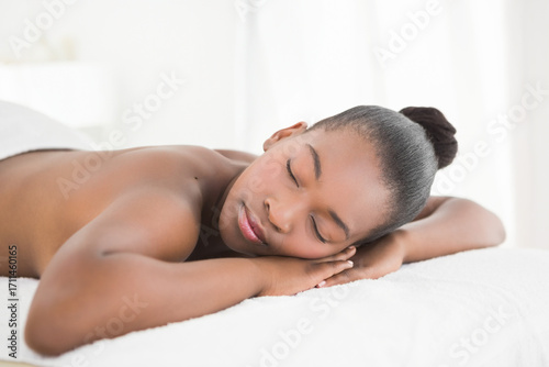 African American woman relaxing peacefully on massage table at spa