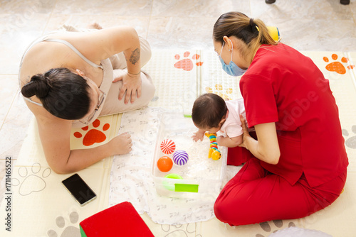 Принти на полотні Baby in a stimulation activity accompanied by the mother and a healthcare profes