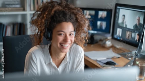 Connected Communication: A smiling individual engages in a dynamic virtual meeting from a home office, embracing modern technology and fostering connections.