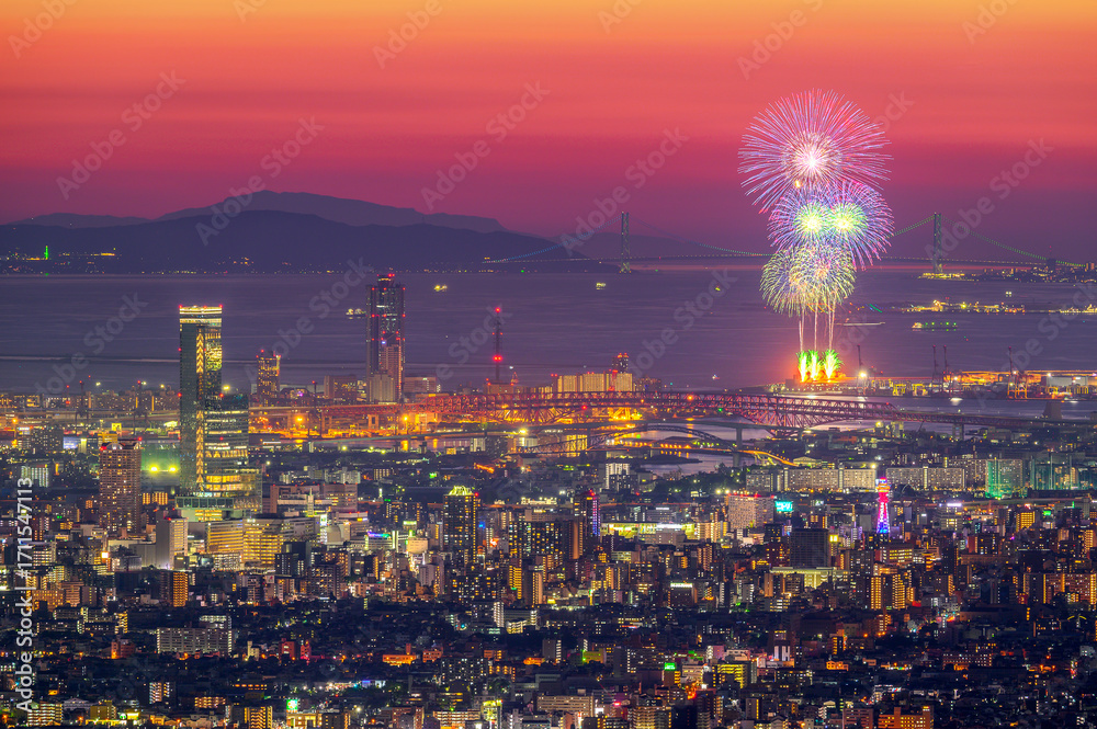 Fototapeta premium 大阪の夕暮れの夜景と打ち上げ花火のアップ