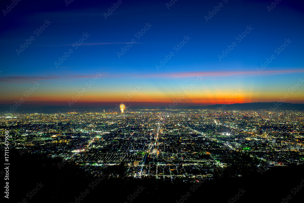 Naklejka premium 大阪の夕暮れの夜景と打ち上げ花火