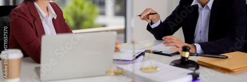 Asian adult legal professionals discuss important documents business meeting office setting justice symbols present for legal counsel guidance