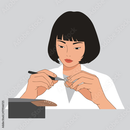 Woman wearing a white coat setting gem on a ring using a tool, on neutral gray background