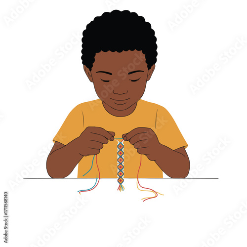 A young boy attentively weaves a colorful friendship bracelet with threads at a table