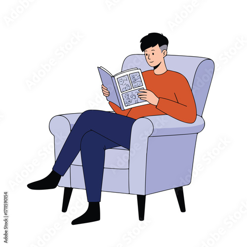 Young man in orange shirt sitting and reading a comic book on a light blue armchair