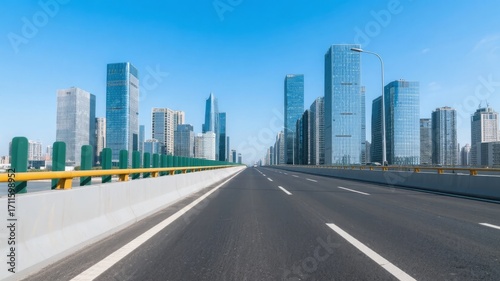 Wide highway leading toward a modern city skyline under clear blue sky