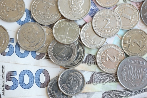 Ukraine money coins lying on mixed hryvnia banknotes. Finance background concept.