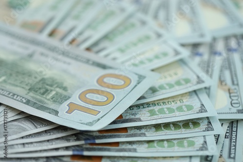 Many hundred dollar bills new banknotes in big pile under the natural light
