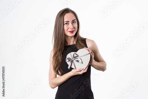 Beautiful woman with a heart-shaped gift in her hands. A gift for a romantic date. Isolated on white