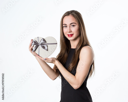 Beautiful woman with a heart-shaped gift in her hands. A gift for a romantic date. Isolated on white