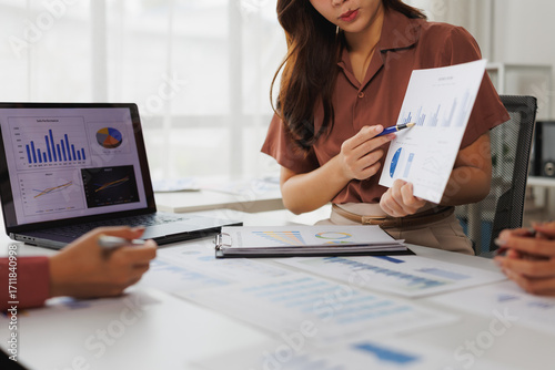 Photography Businesswomen analyzing financial charts and graphs during meeting