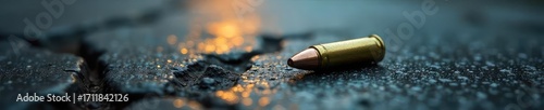 A somber image depicting a single bullet casing lying on a cracked pavement, symbolizing the harsh reality of gun violence in urban areas , justice, emergency
