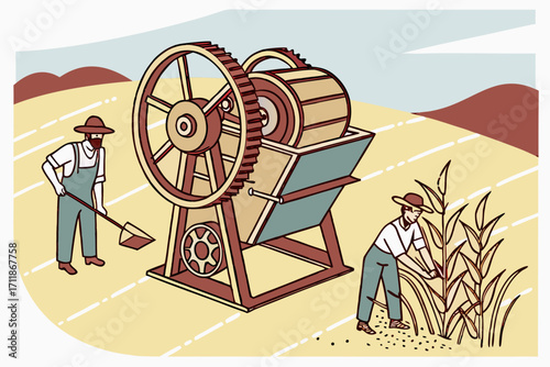 Farmers operating vintage threshing machine in field.