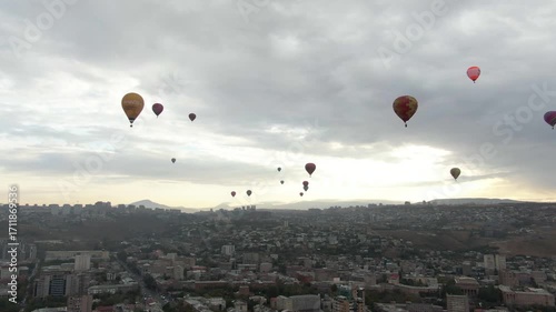 Hot air balloons fill the sky over a city at sunrise․ angle view of hot air balloons flying in the sky. Colorful hot air balloons fill the sky during a lively festival