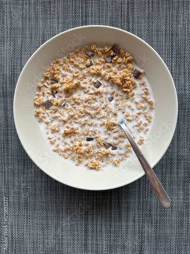 Crunchy muesli with chocolate chunks and milk in a bowl, healthy breakfast choice
