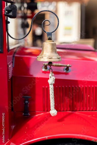 Brass bell with rope pull hanging from a red city children's sightseeing train