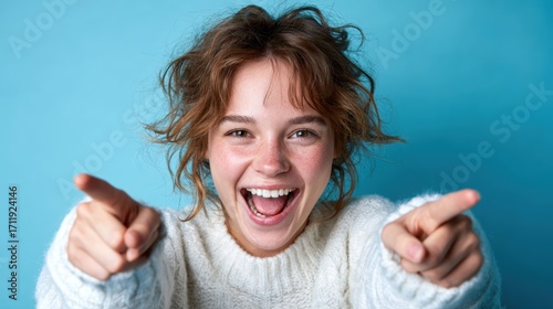A vibrant image of a joyful woman laughing energetically against a bright blue backdrop, capturing her exuberance and positivity, perfect for conveying happiness and vivacity.