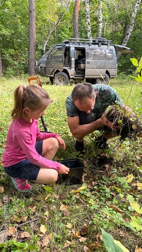Father and daughter planting a tree. Greening nature.