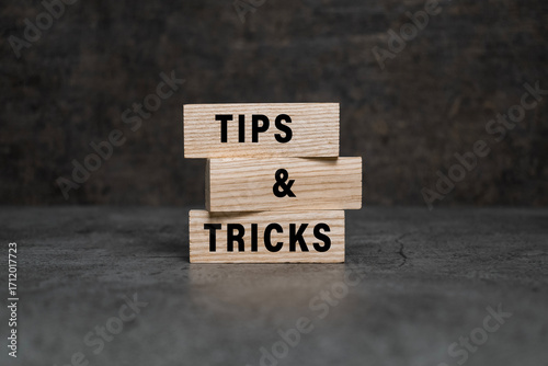 tips and tricks words on wooden blocks isolated on dark background