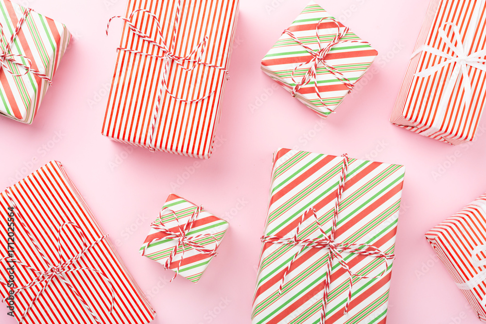 Obraz premium Many striped Christmas gift boxes on color background, top view