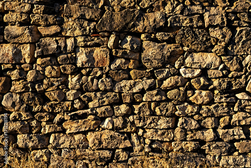View of old wall built with stones in warm tones. Concept for backgrounds and textures.