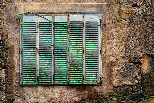 Window in a stone wall. Rural architecture in Spain abandoned and semi-demolished due to migration to cities.