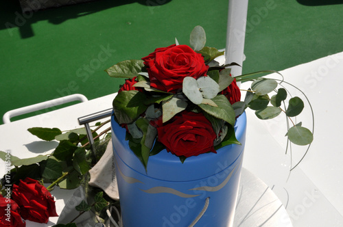 Seebestattung: eine blaue Urne mit Rosen wird auf das offene Meer gefahren.