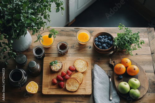 Assorted fruits and bread on wooden cutting board.