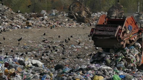 Garbage truck unloads garbage at the landfill. The work of a garbage truck at a waste disposal site. Ecology and environmental pollution concept. People's environmental problems.