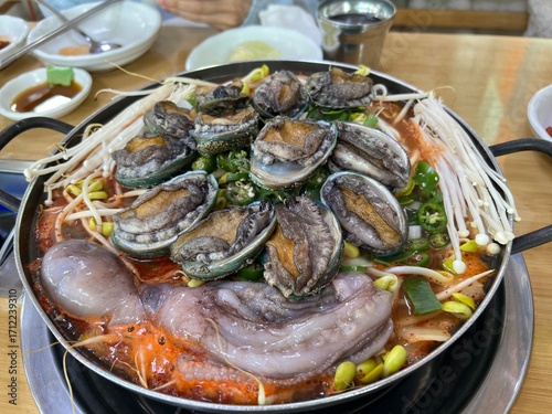 동그란 냄비에 담긴 맛있는 콩나물과 전복, 낙지,새우 해물탕 