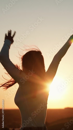 Holiday party. Beautiful girl dancing and having fun with friends at sunset disco. Young smiling woman dancing against sky outdoors. Cheerful woman moving her hands to music at party. Party on beach