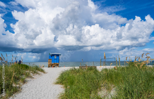 Path to Venice Beach on the Gulf of America, formerly the Gulf of Mexico, with rain storm clouds over the water in Venice Florida USA