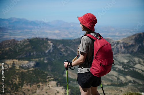 Young Woman Hiking with Scenic Mountain Views and Red Backpack
