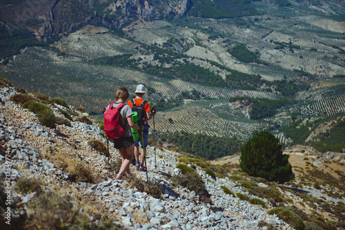 Hikers Exploring Rocky Terrain Amid Stunning Views of Agricultural Valleys