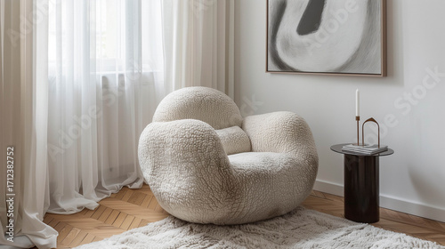 Stylish minimal room with sculptural boucle armchair and abstract art in bright natural light