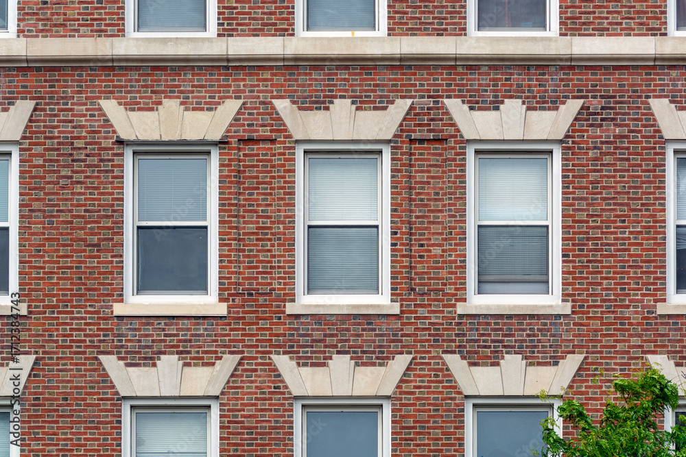 Fototapeta premium Classic red brick facade with orderly windows revealing timeless urban residential architecture in Cambridge, Massachusetts, USA 