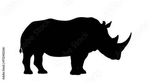 Silhouette of a rhinoceros standing, showcasing its distinctive horn and powerful build against a white background.