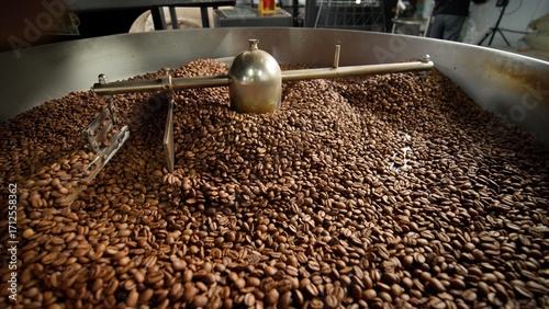 Foto Fresh roasted coffee beans cooling in large industrial mixer machine roaster ble