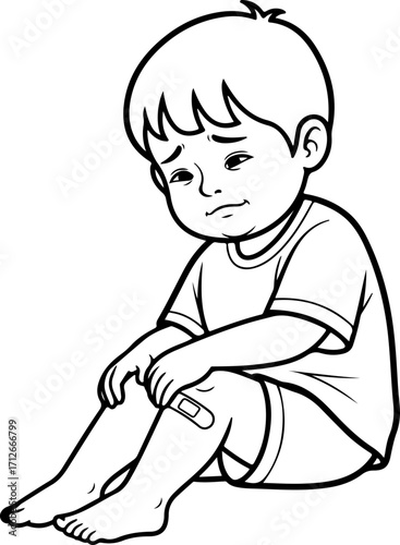 A sad young boy sitting down with a bandage on his knee, looking down with a pained expression.