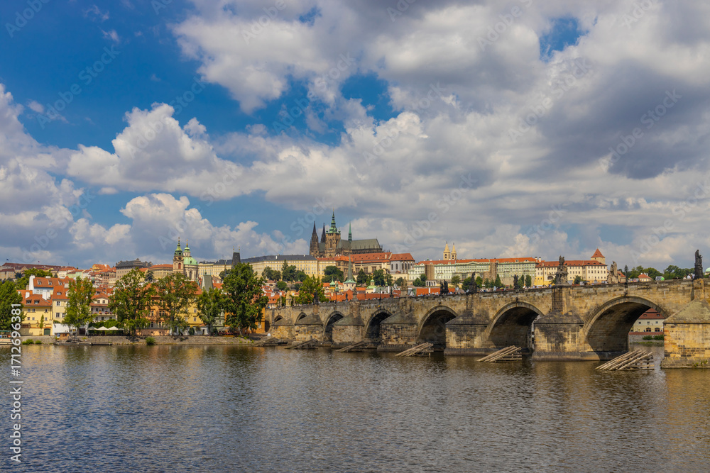 Obraz premium Prague cityscape, the capital of Czech Republic tourist sights. Prague historic center district at Charles bridge during the day. Busy tourist area city sights of Prague, capital of Czech