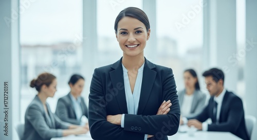 Confident businesswoman standing with arms crossed in office