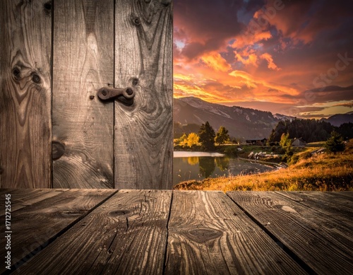 Rustic Wooden Door Opens to a Scenic Landscape at Sunset Featuring a Tranquil Lake and Silhouetted Mountains with Vibrant Orange and Pink Clouds