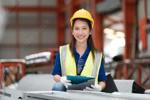 Metalwork manufacturing. Asian woman worker check quality of galvanized roof after manufacturing process in factory. Female factory worker inspecting galvanized roof in storage warehouse