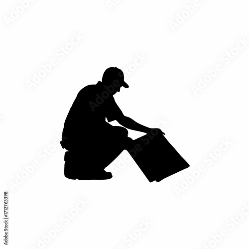 Silhouette of installer crouching aligning roofing sheet edges isolated on white background