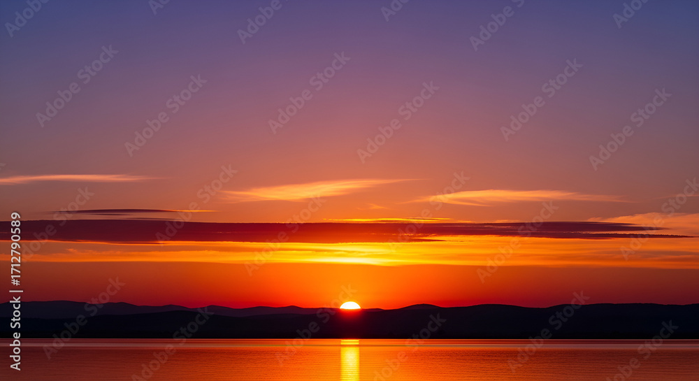 Obraz premium Beautiful sunset over the lake with sun reflecting on the water surface